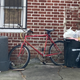 The bike, forlorn, waiting by the trash. Even at this moment, I knew that maybe someone wanted to hold on to it.